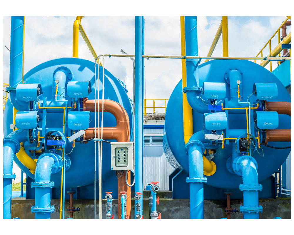 Deux cuves bleues avec tuyauteries orange et bleue et boitiers électriques devant